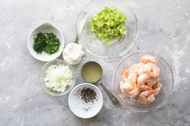 Shrimp salad ingredients in various bowls.