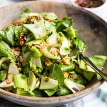 Baby bok choy salad with sesame dressing in a wooden bowl.