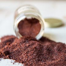 A closeup of ancho chile powder spilled onto a counter.