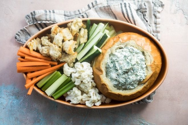 Knorr spinach dip in a bread bowl with various veggies and bread chunks.