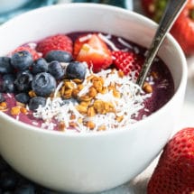 Easy acai bowl in a white bowl with a spoon.