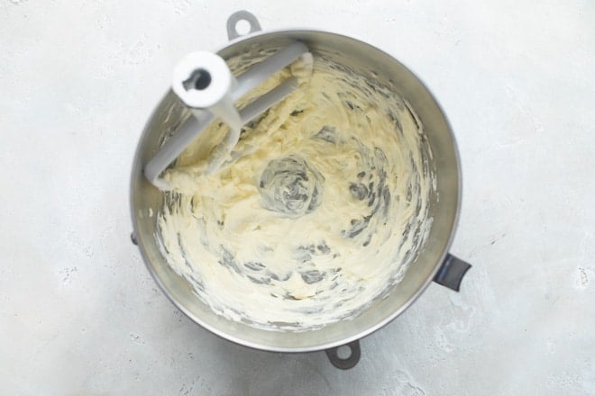 A mixing bowl with butter creamed to be pale and fluffy.