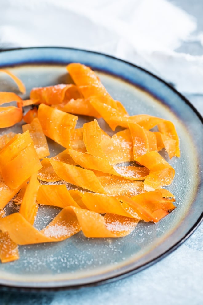 Candied carrot curls on a blue plate.