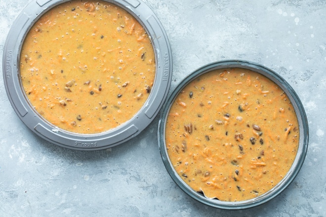 Carrot cake batter in two round cake pans.