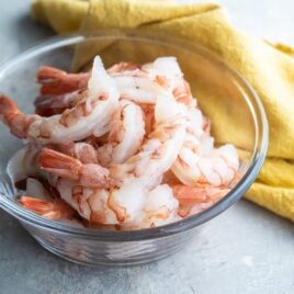 Raw shrimp in a clear bowl.
