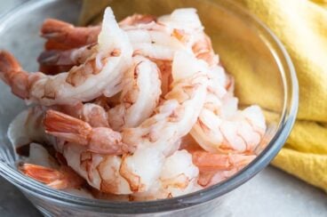 Raw shrimp in a clear bowl.