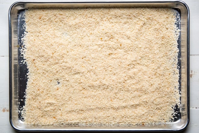 Breadcrumbs on a sliver baking sheet. 