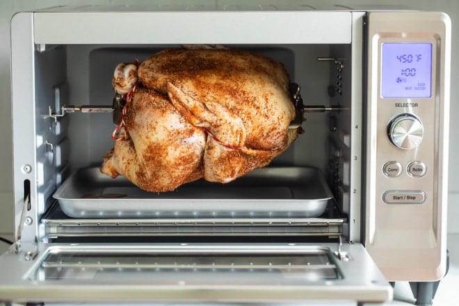 A raw chicken in a rotisserie oven.