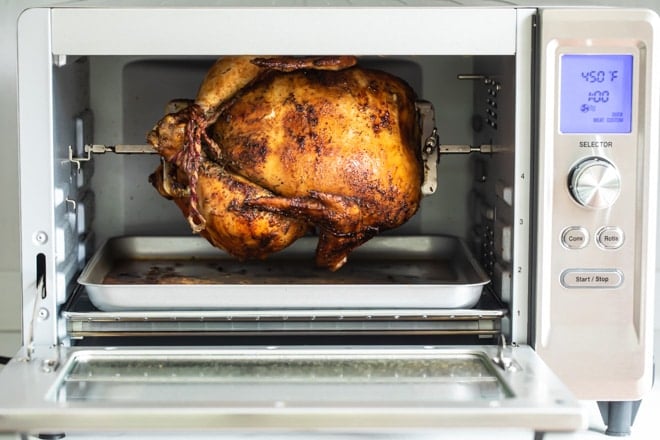 A cooked chicken in a rotisserie oven.