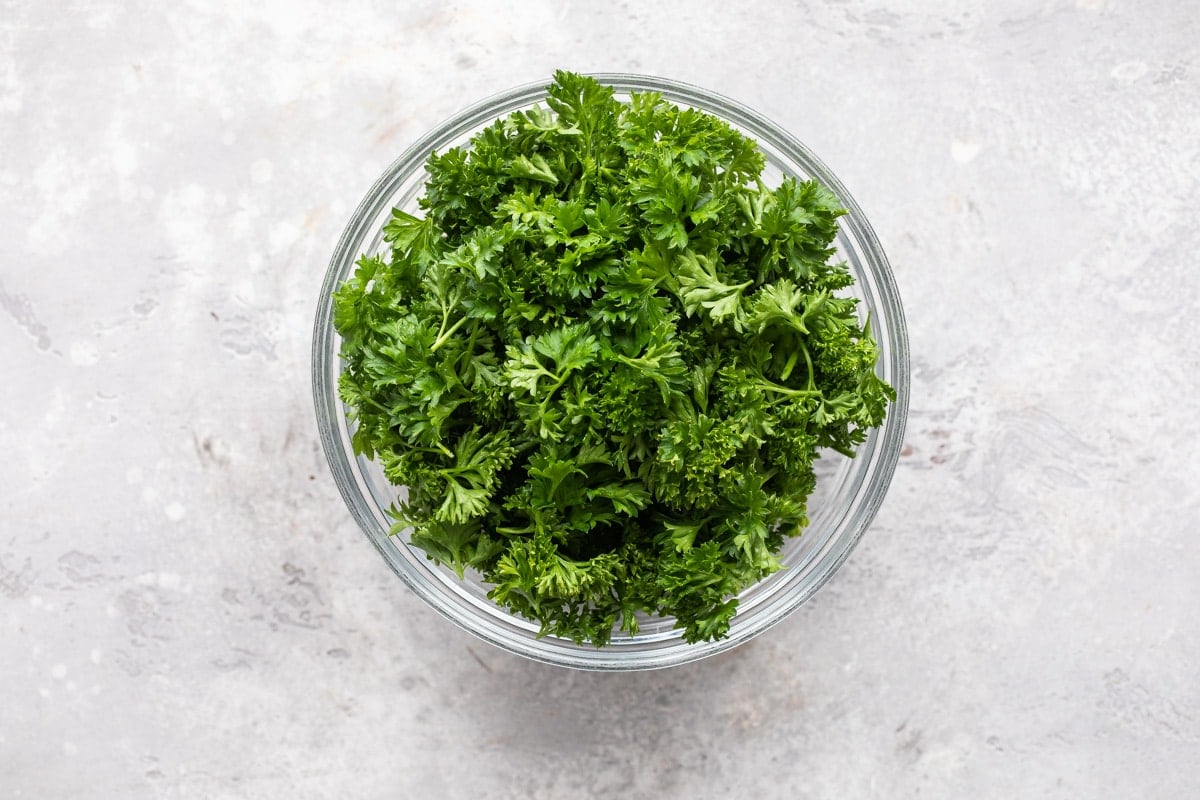 Curly parsley in a clear bowl.