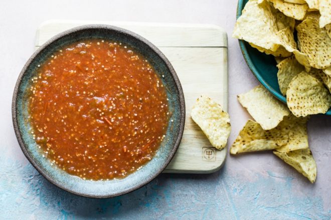 Salsa de Birrio in a gray serving bowl with chips next to it.