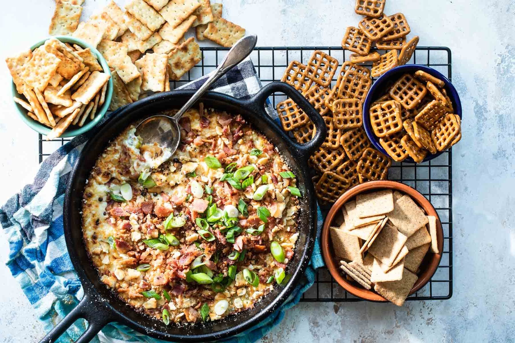 Cheesy bacon dip in a cast iron skillet.