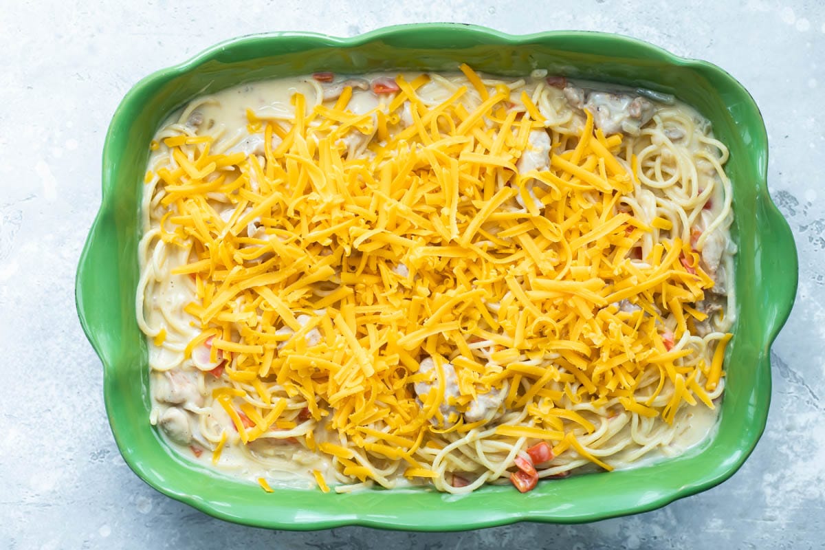 Chicken spaghetti in a green baking dish before being baked.