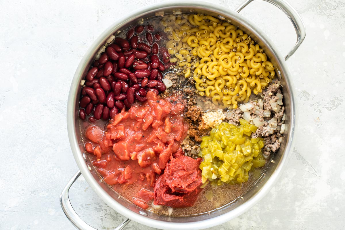 Chili mac ingredients in a Dutch oven before being mixed.