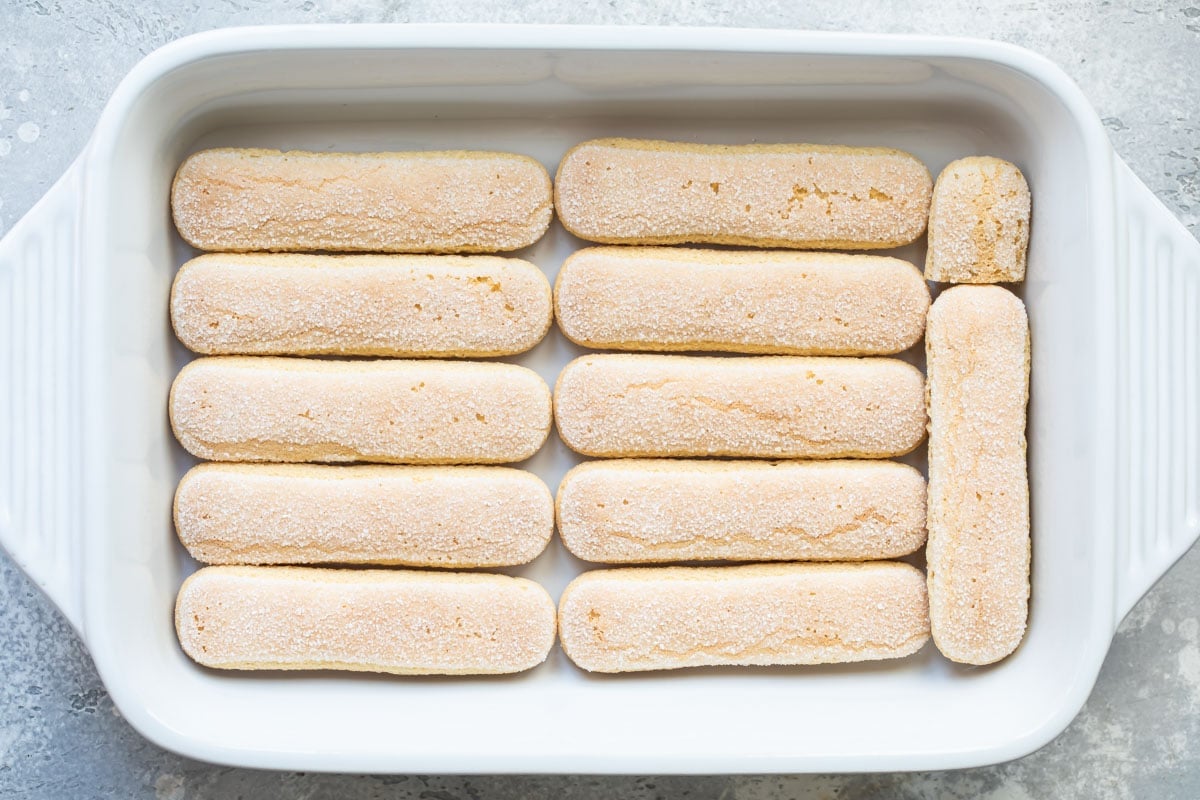 Lady fingers in a white rectangular baking dish.