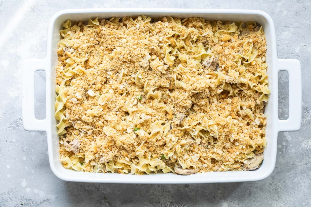 Tuna noodle casserole in a white baking dish before baking.