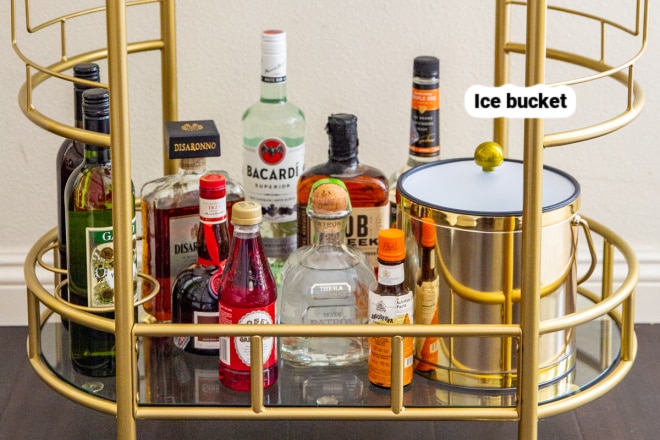 The bottom tier of a stocked bar cart.