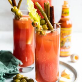 Two bloody marys with garnishes.