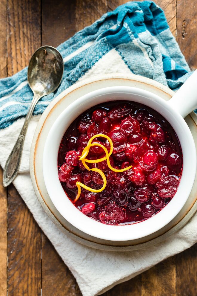 A bowl of cranberry sauce with a spoon next to it.