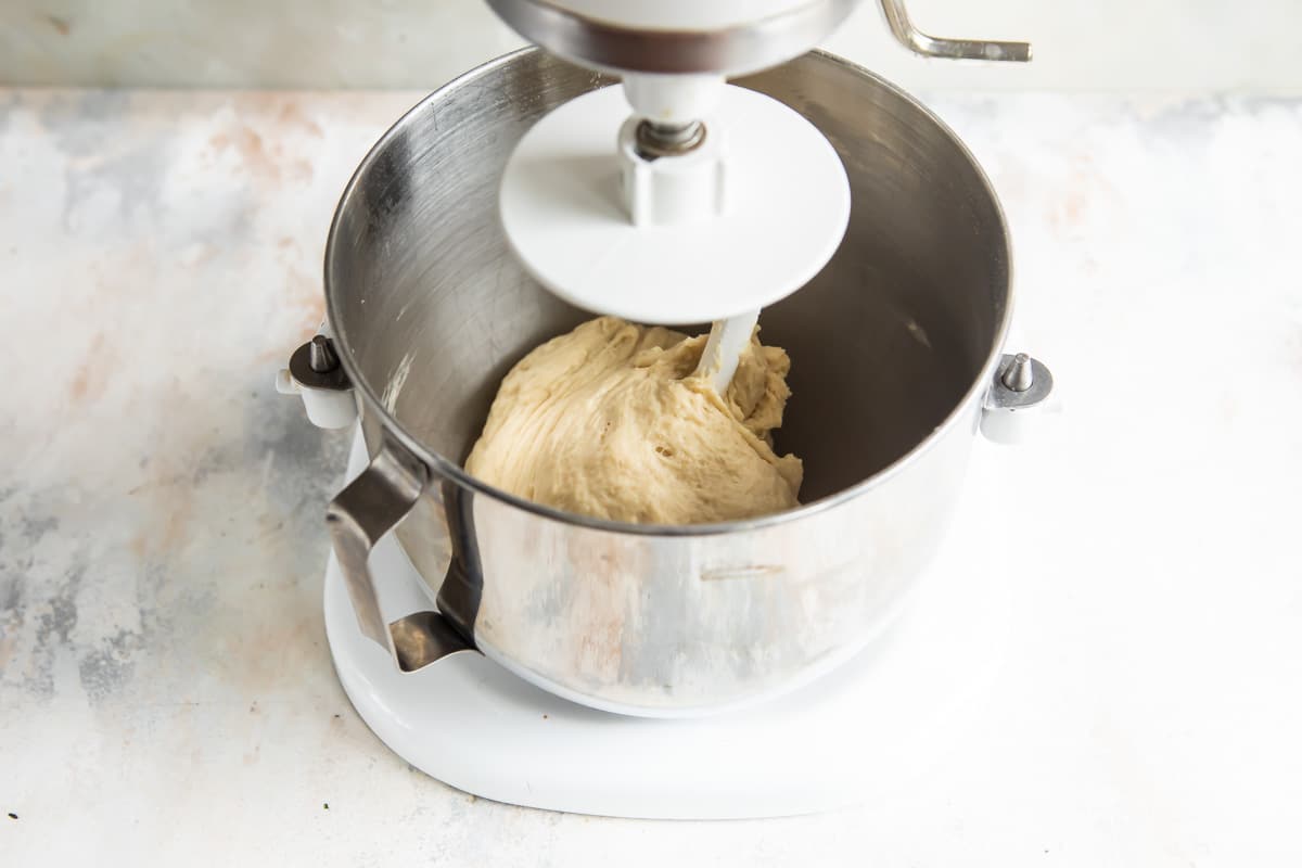 Cinnamon roll dough in a standing mixer.
