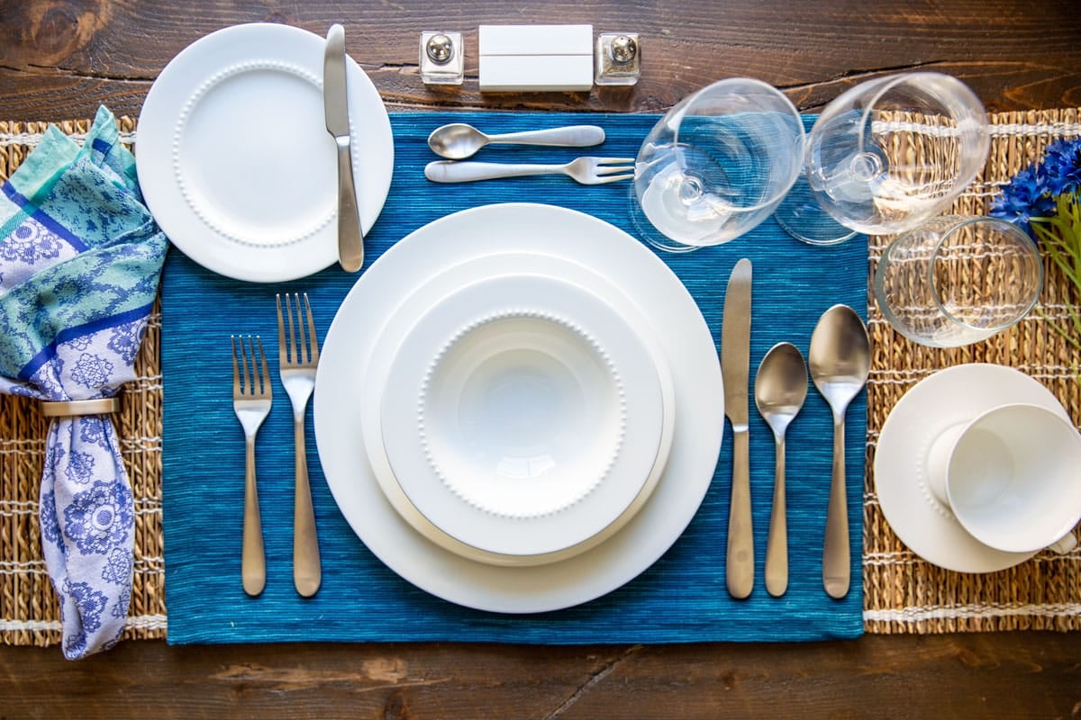A formal table set with bone china, silverware, and glassware.
