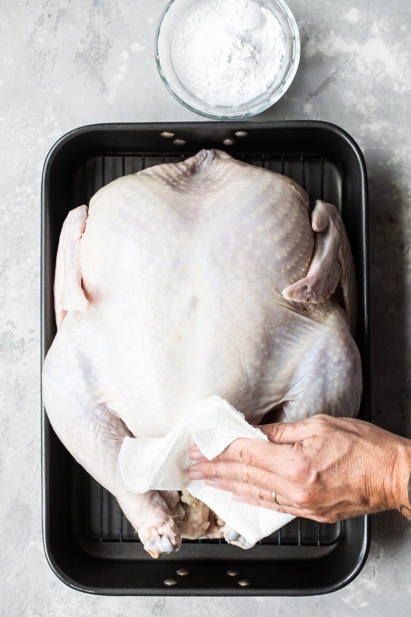 A frozen turkey thawing in a roasting pan.