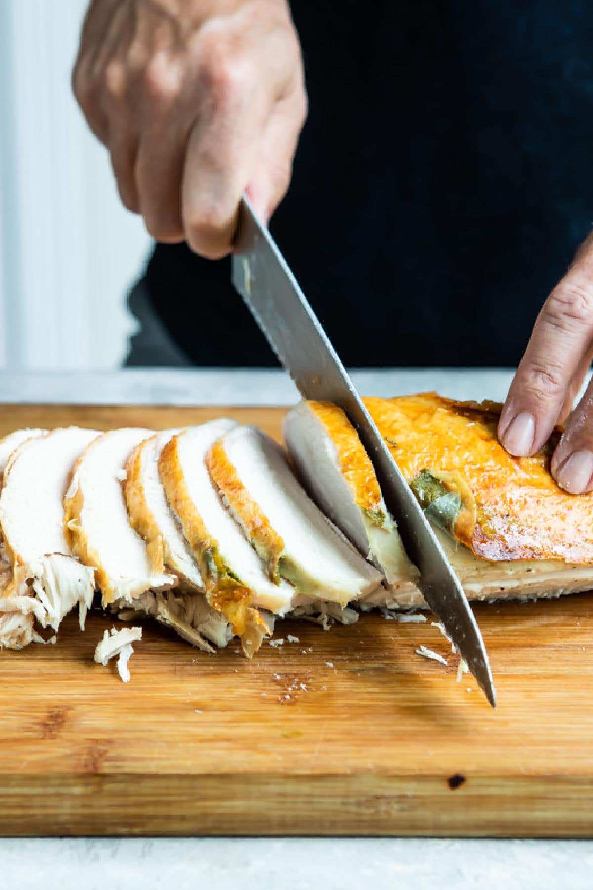 Carving roasted turkey breast into slices.