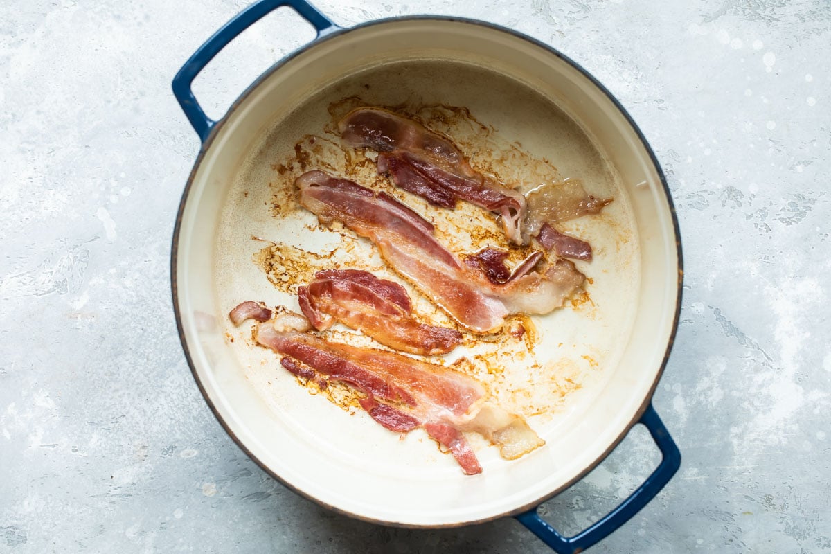 Bacon cooking in a stock pot.
