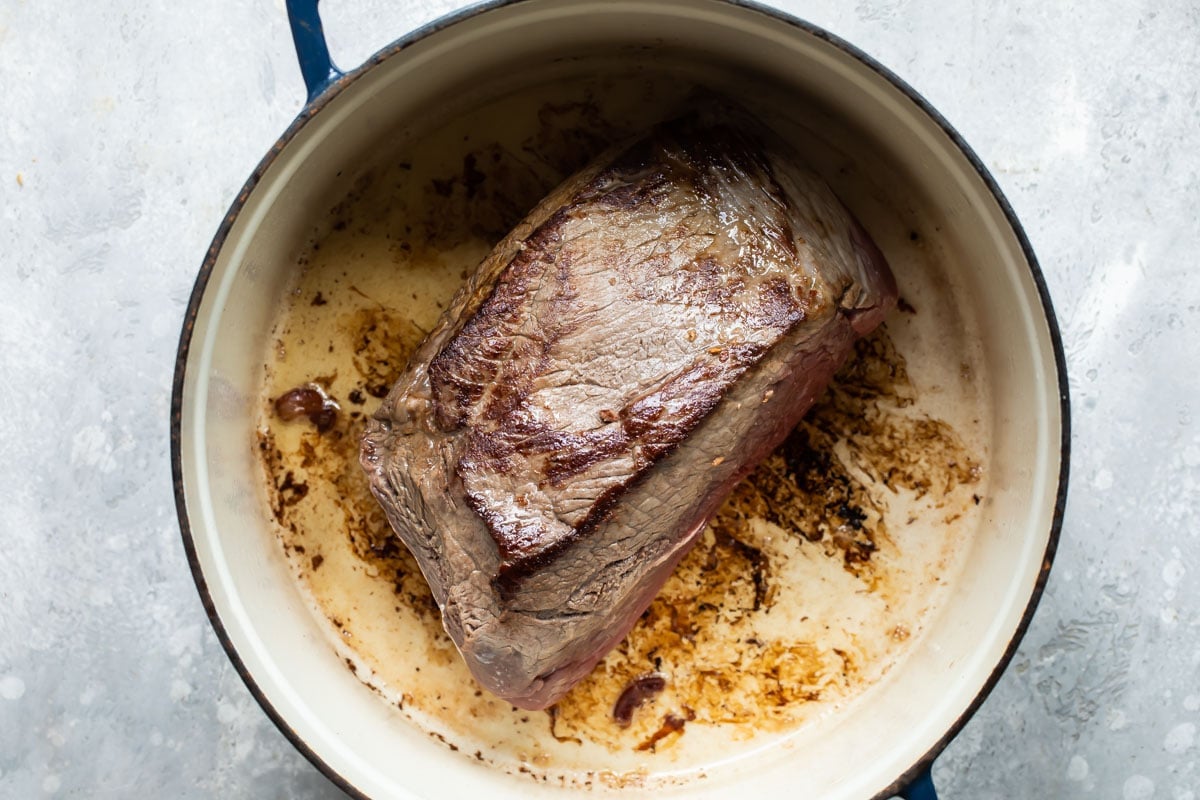 Browning a beef roast in a stock pot.