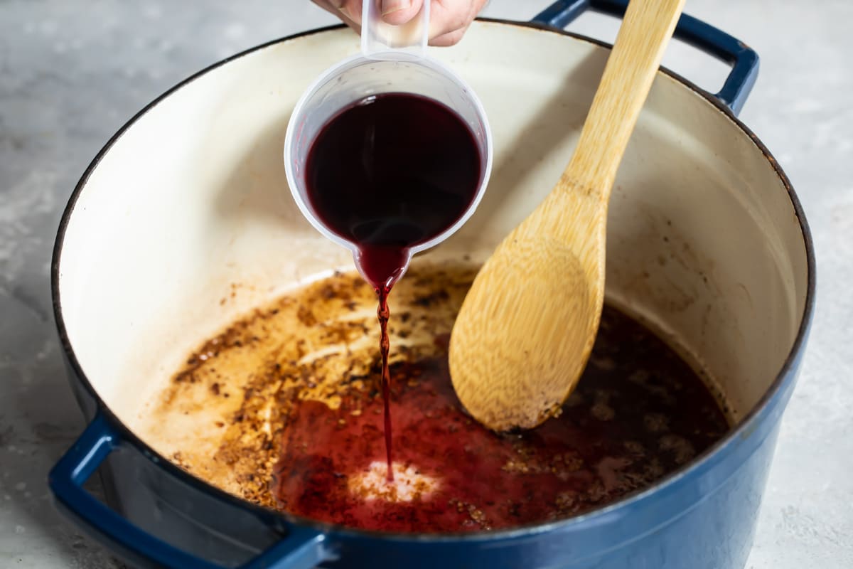 Deglazing a stock pot with red wine.
