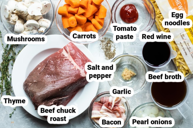 Labeled ingredients for beef bourguignon in various bowls.