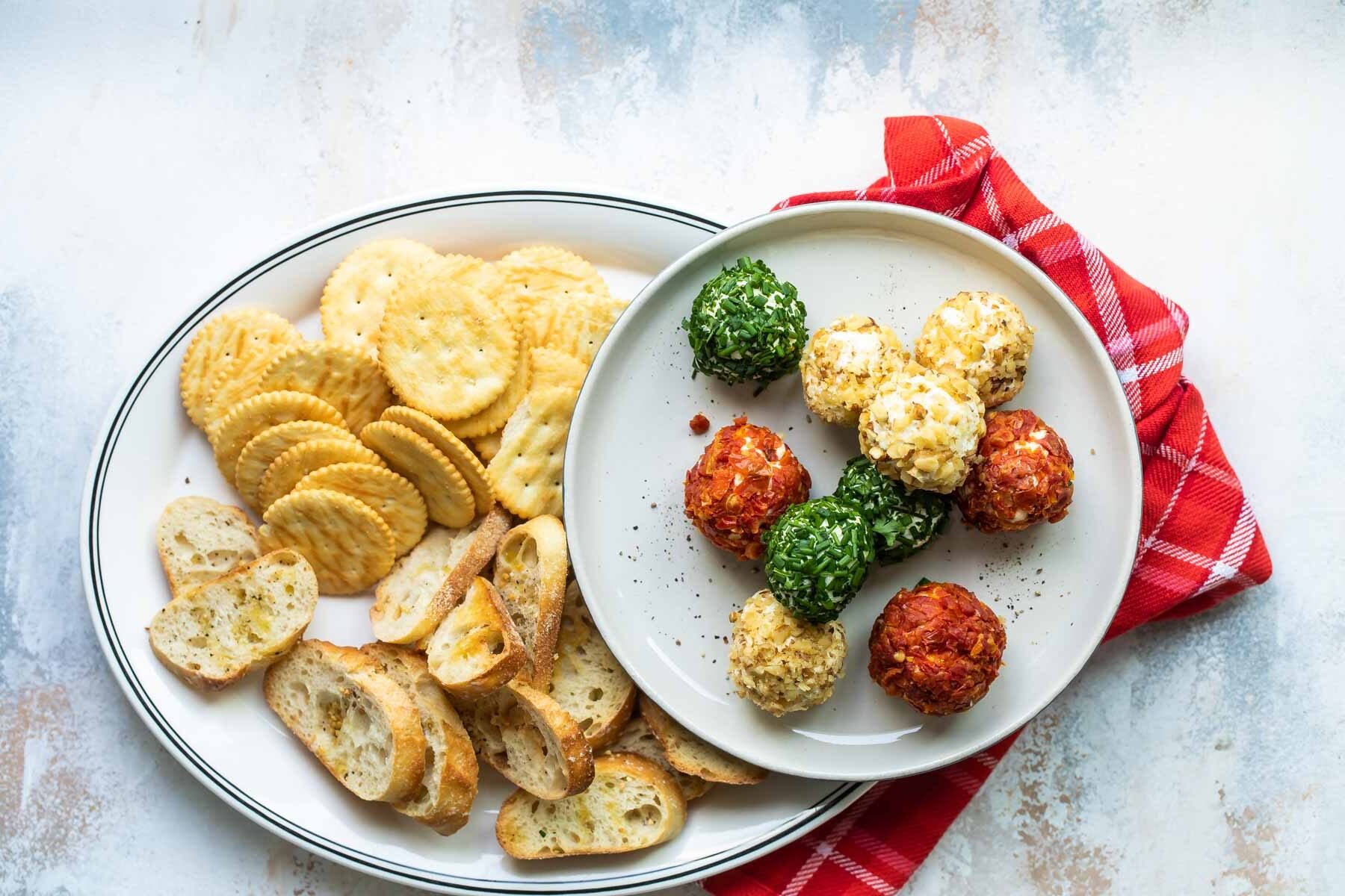 Mini cheese balls on a platter with crackers and crostini.