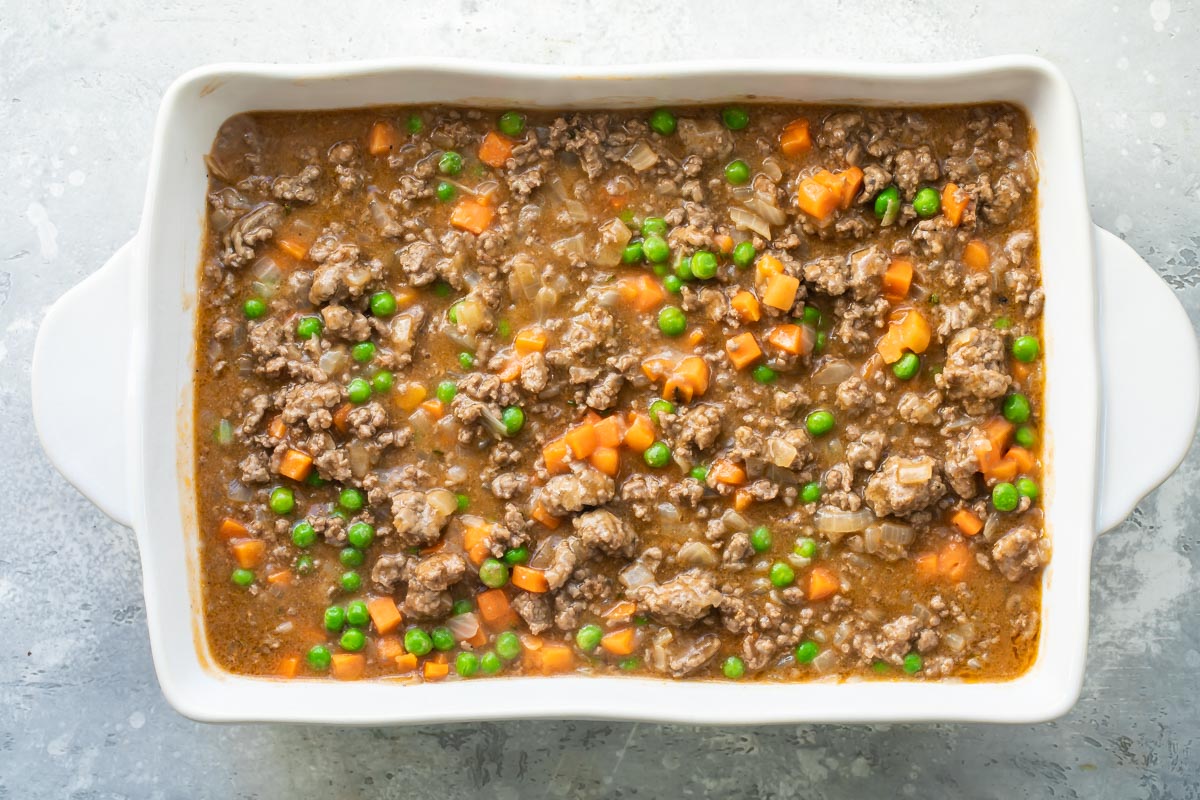 A baking dish full of Shepherd's Pie before the potato topping is added.