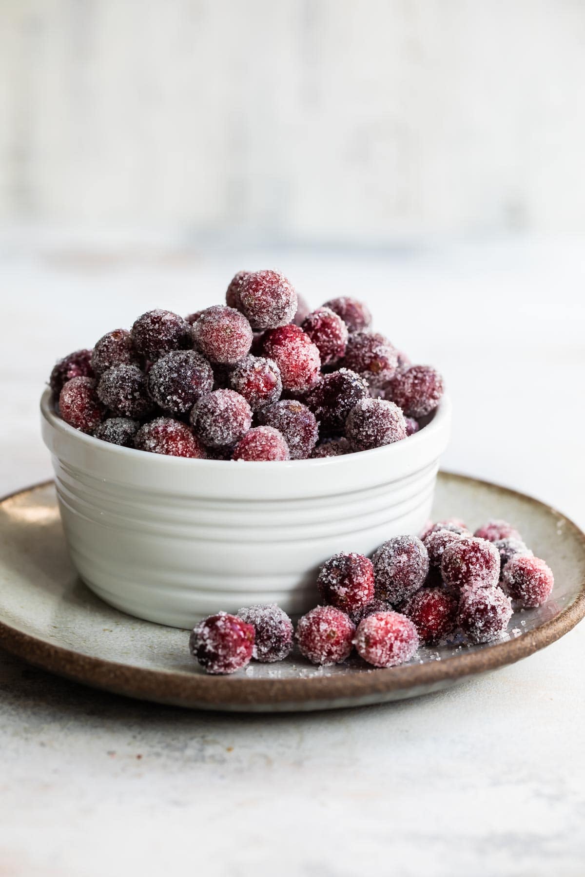 Sugared cranberries in a small white bowl.