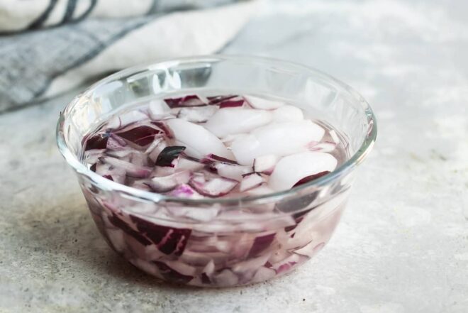 Red onions soaking in ice water to mellow the flavor.