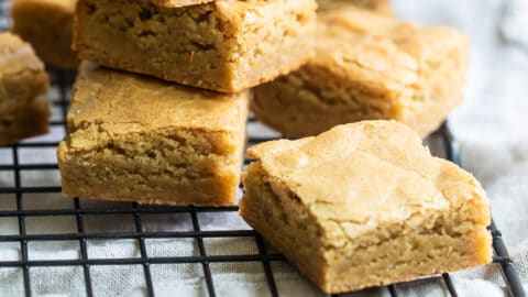 A stack of blondies on a cooling rack.