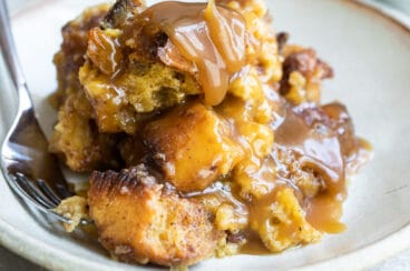 A plate of bread pudding with a fork resting on it.