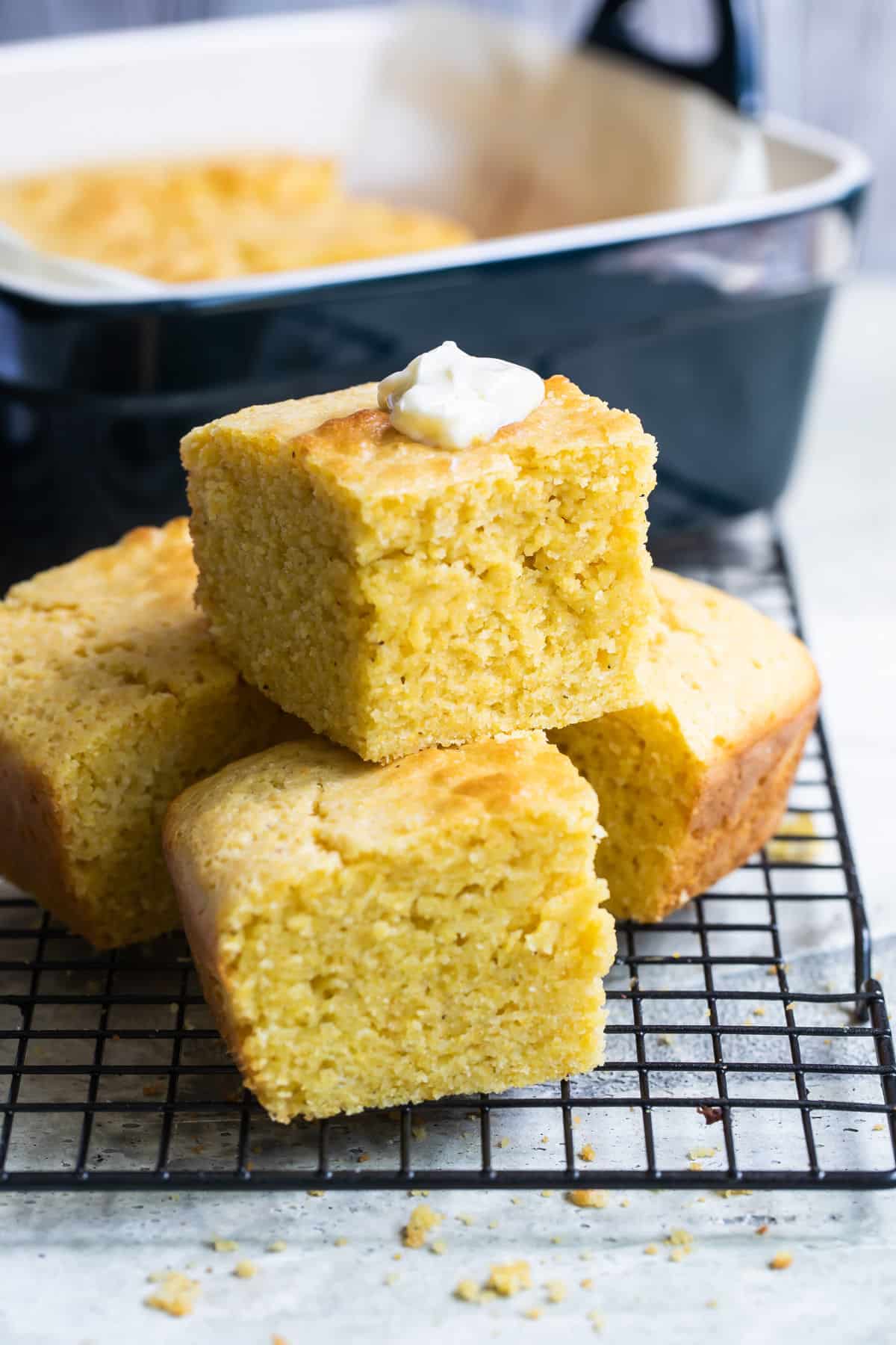 Four squares of cornbread on a cooling rack.