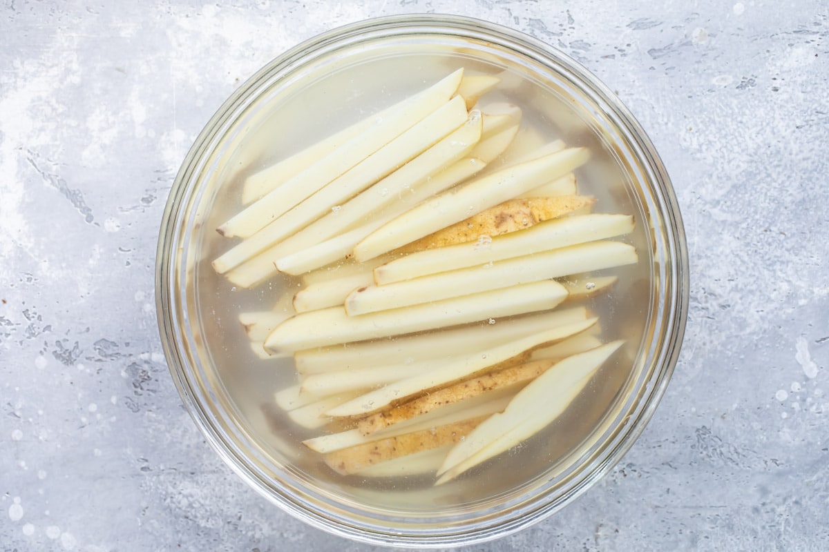 Raw French fries soaking in water.