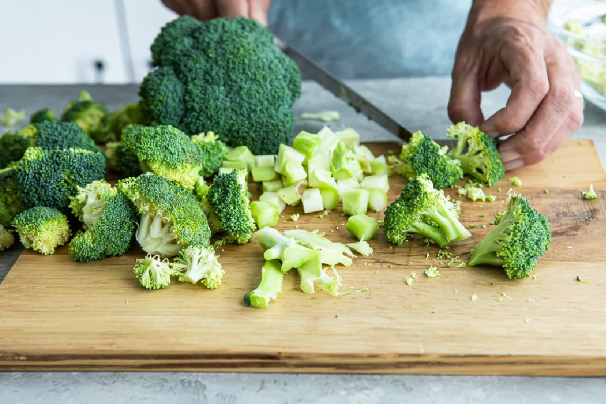 Cut up broccoli on a cutting board.