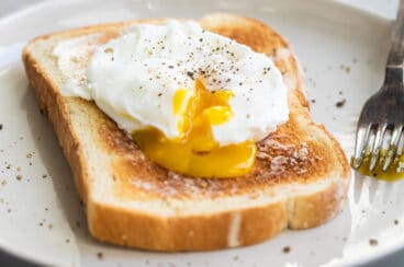 A poached egg on a slice of white toast.