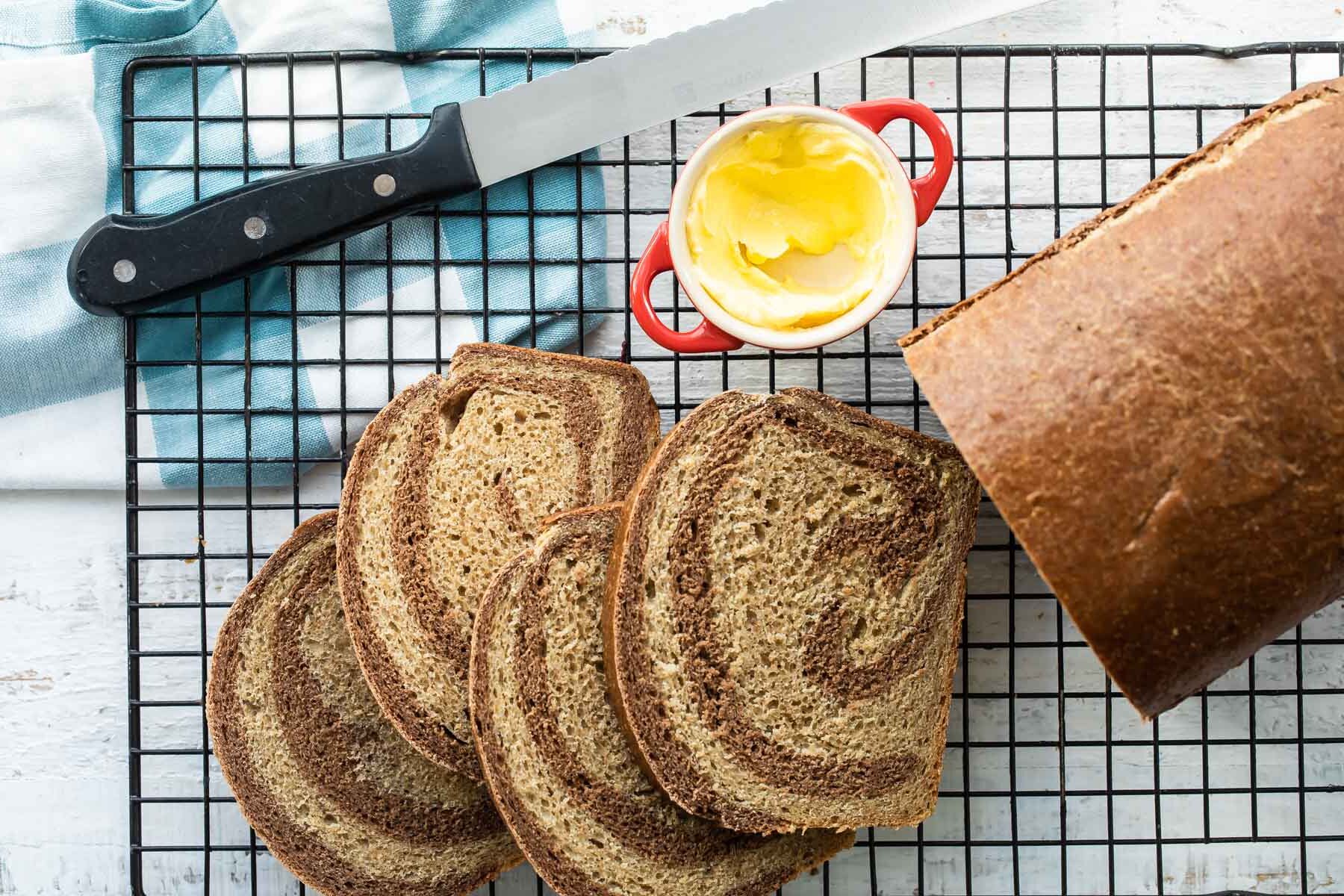 Marble rye bread on a cooling rack.