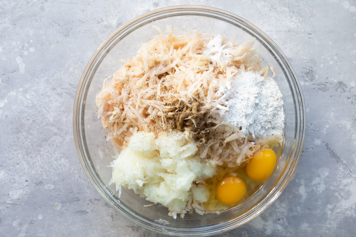 Potato latke ingredients in a bowl.