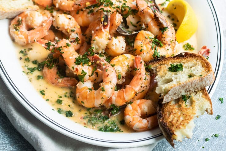 Shrimp scampi on a white platter.