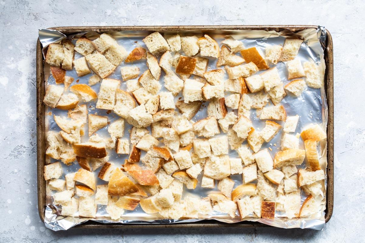 Bread cubes drying on a baking sheet for stuffing.