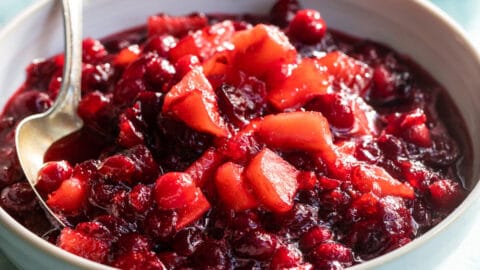 A bowl of cranberry sauce with apples.