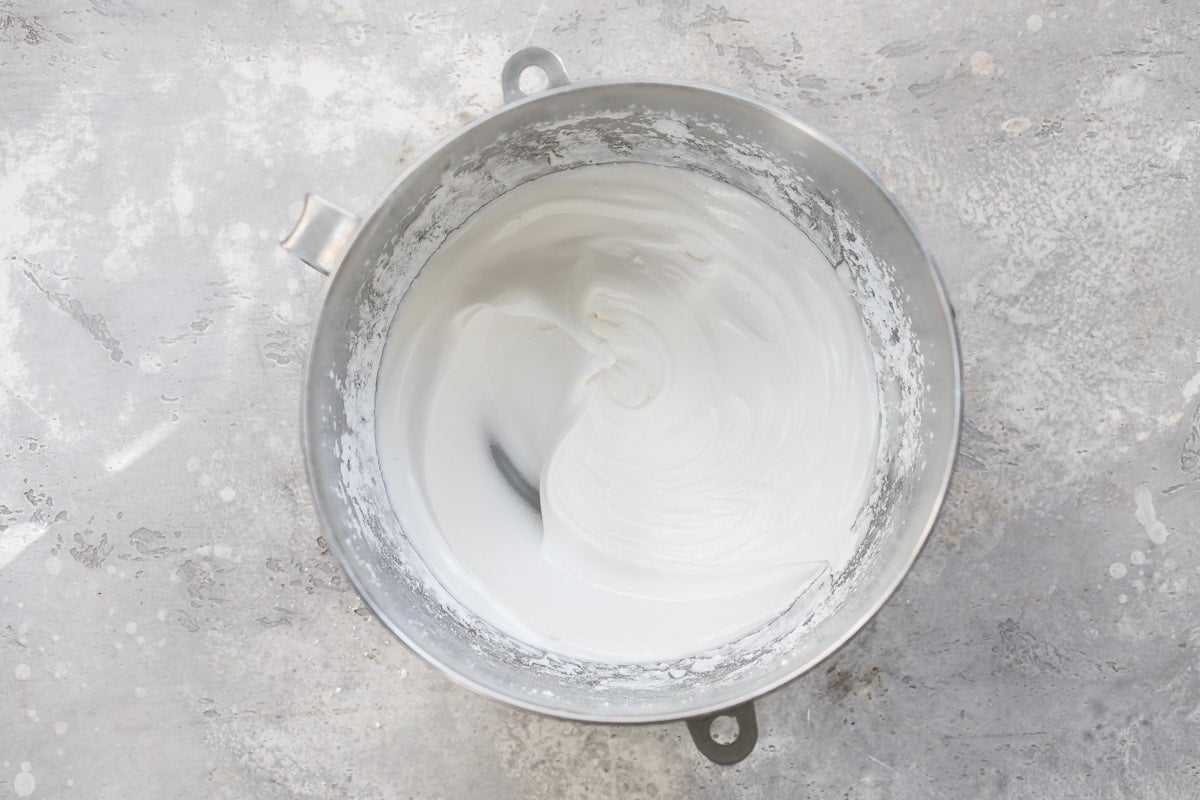 Frosting ingredients mixed together in a silver mixing bowl.