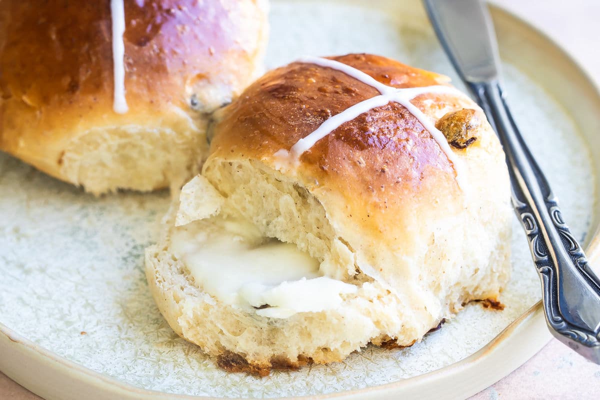 Hot cross buns on a white plate.