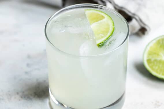 A Paloma cocktail in a rocks glass garnished with lime.