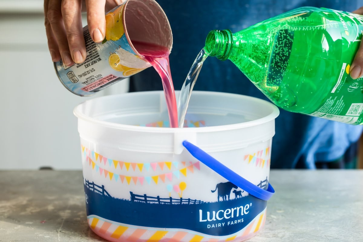 Making pink lemonade vodka slush in an ice cream pail.